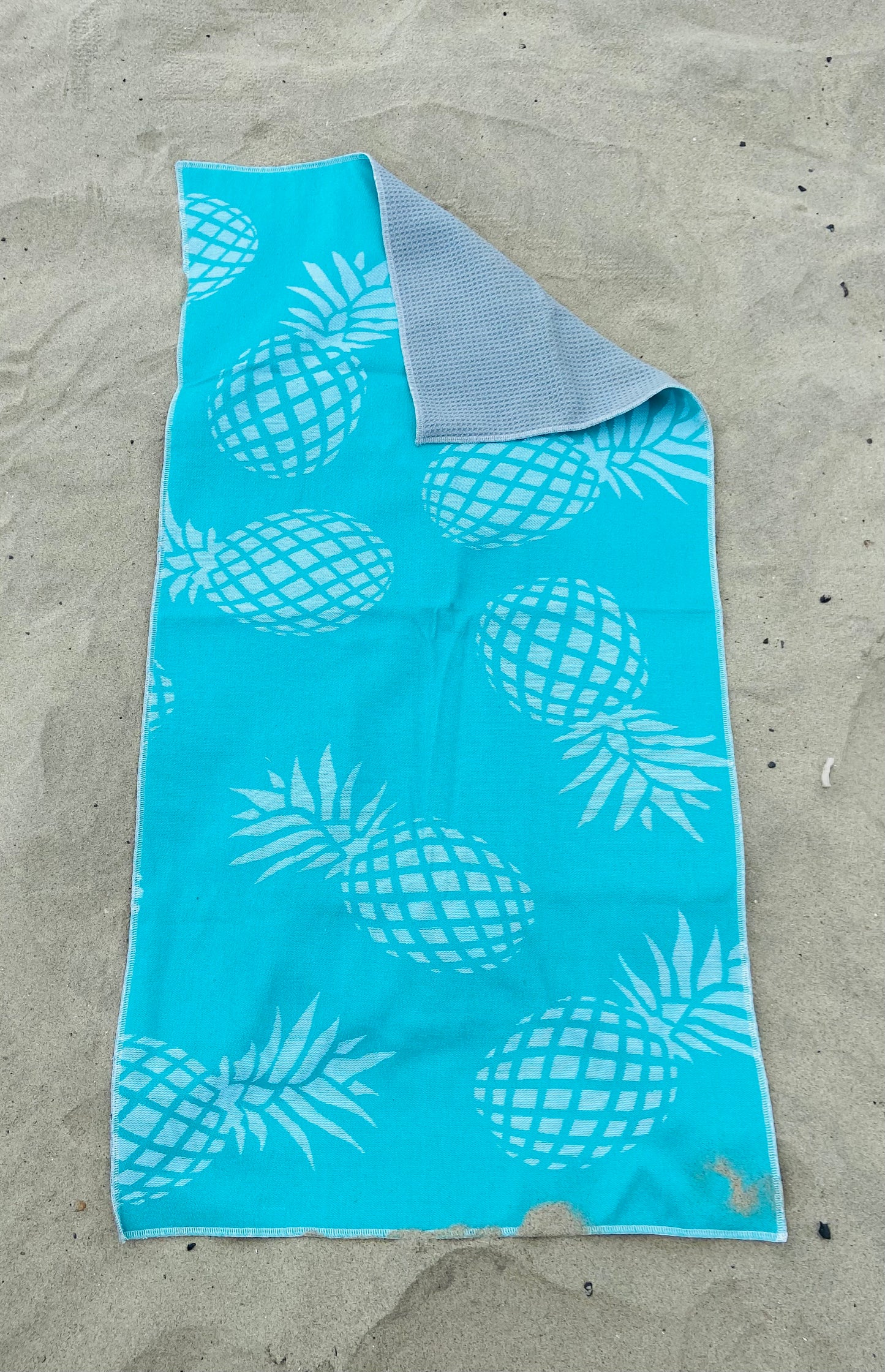 Large Teal Pineapple Golf Towel with Gray Interior on Sand