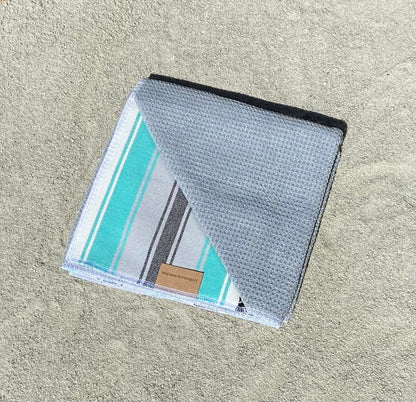 Teal Baja Surf Golf Towel with Gray Interior on Sand